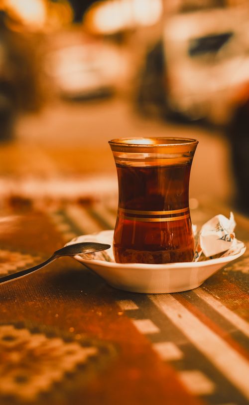 Free A warm cup of Turkish tea in a tulip glass on a patterned tablecloth in Bursa, Türkiye. Stock Photo