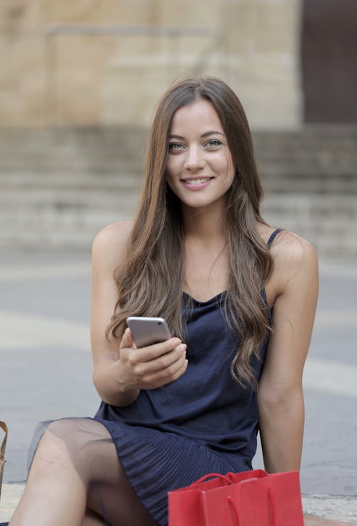 Frau Im Blauen ärmellosen Kleid, Das Silbernes I Phone 6 Hält