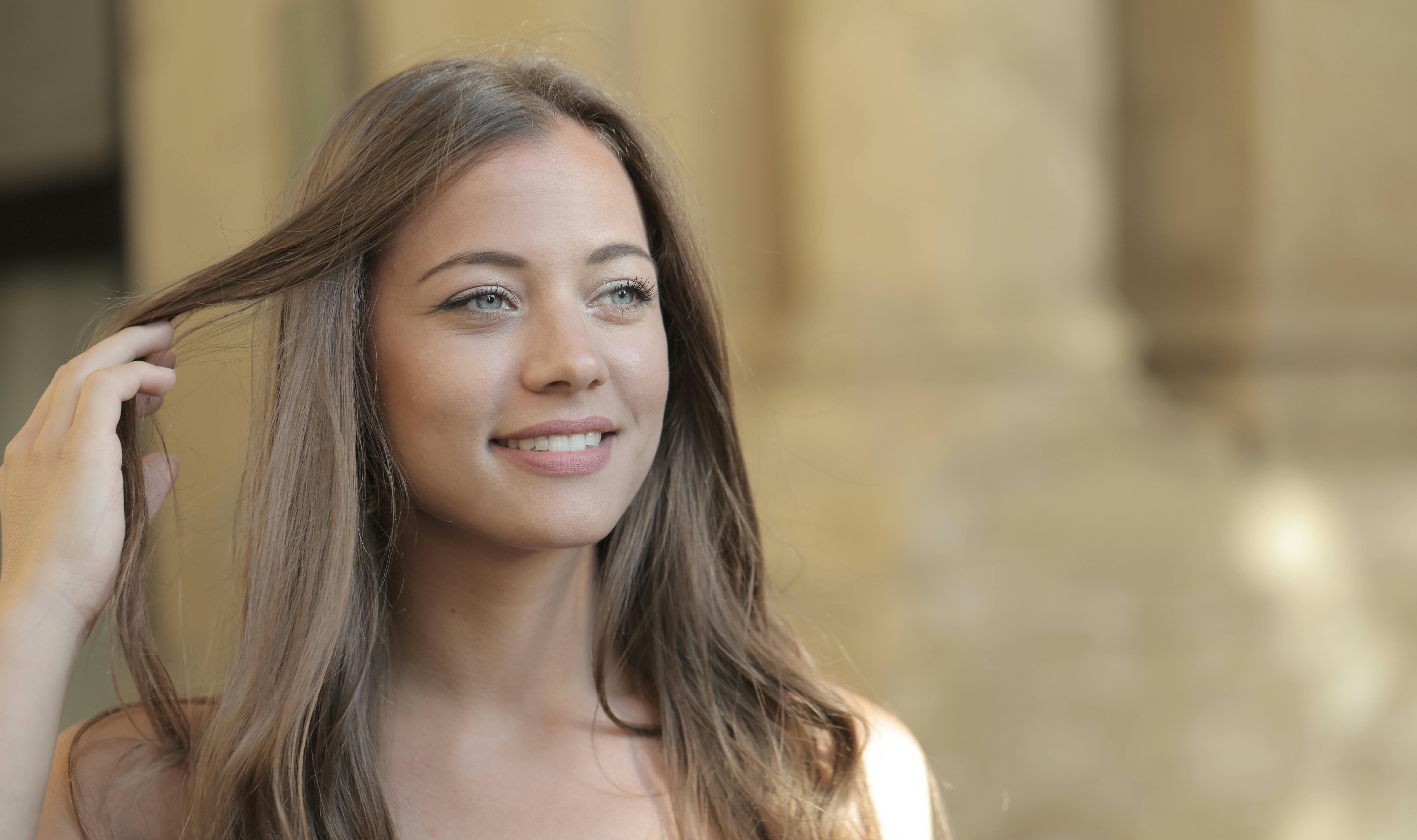 woman in holding her hair smiling