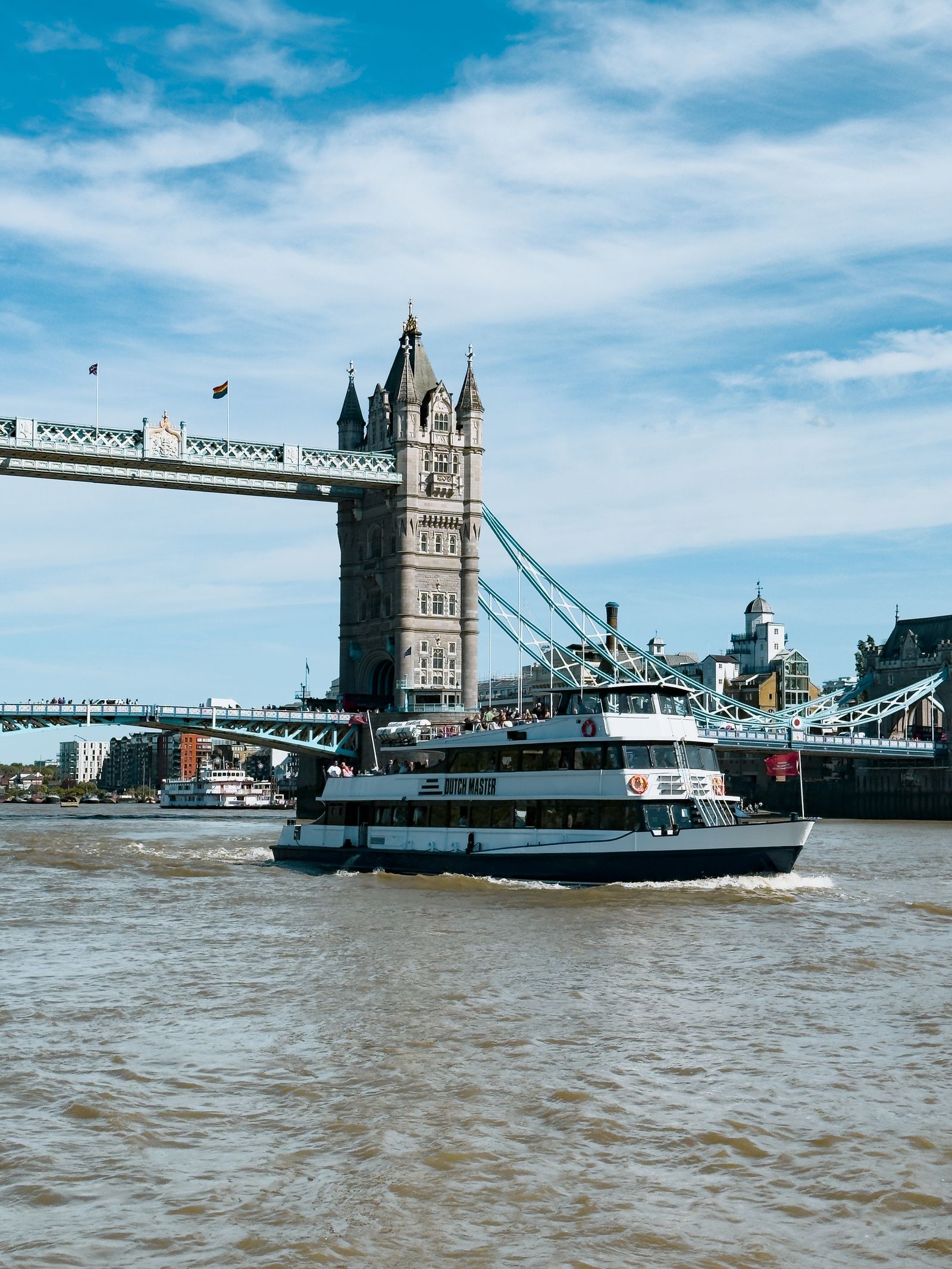 A sightseeing boat cruising past Tower Bridge on the River Thames
