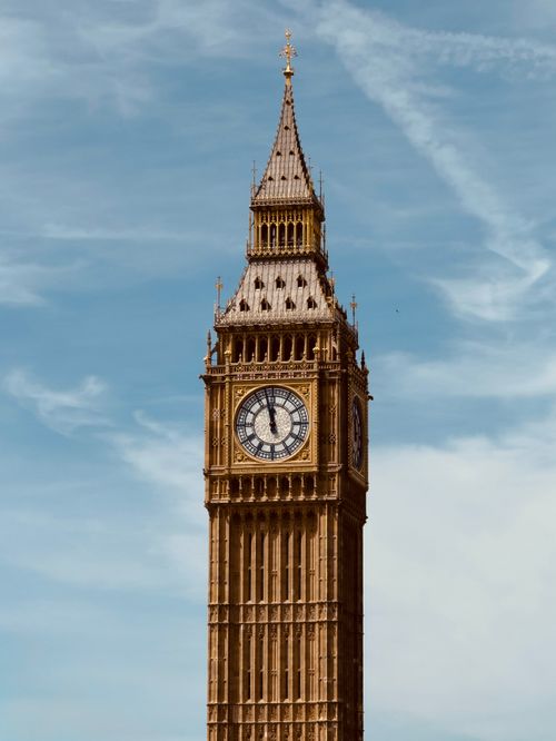 Free Close-up view of London's famous Big Ben clock tower on a clear day with a blue sky backdrop. Stock Photo