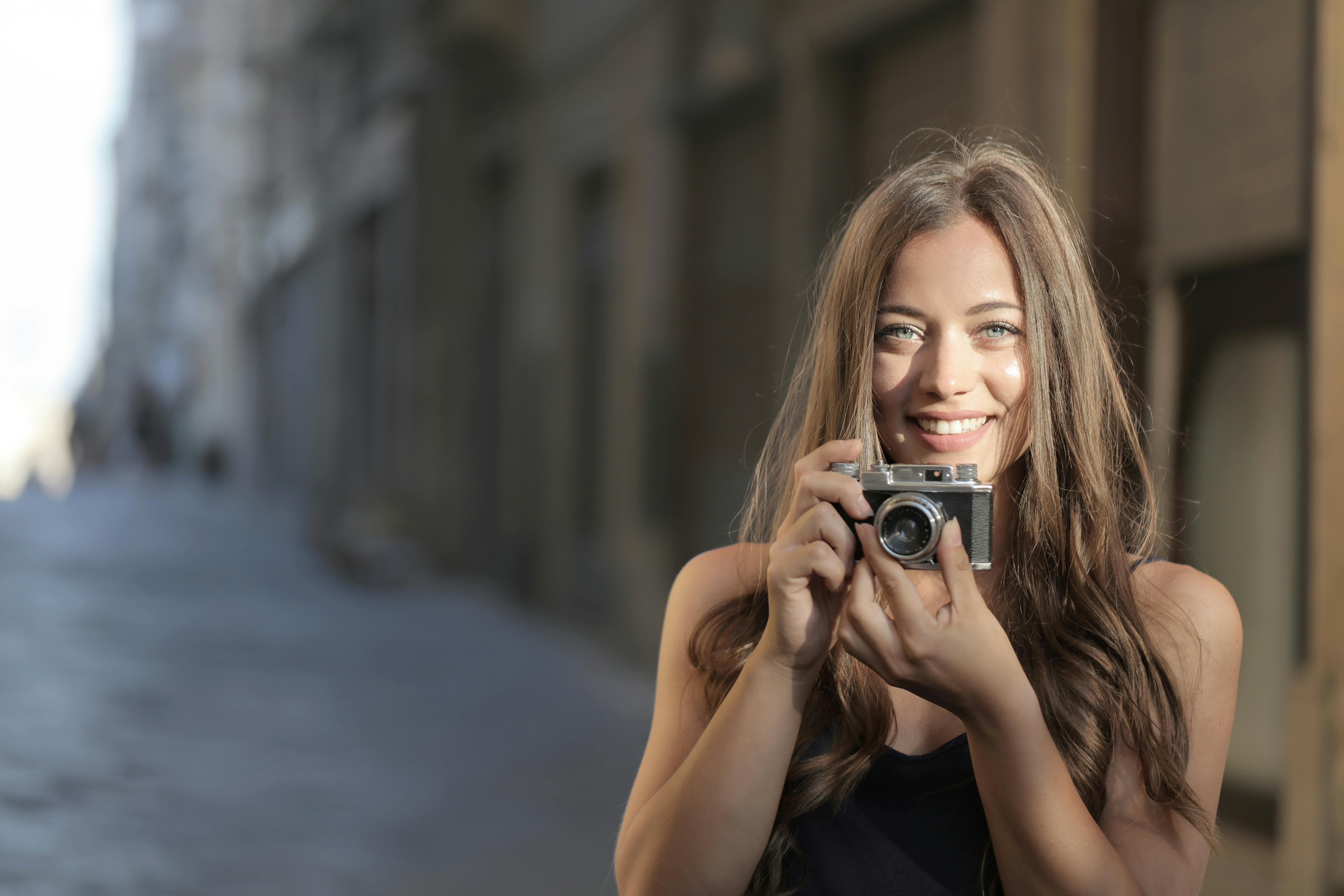 Ücretsiz Siyah Kolsuz Bluz Siyah Ve Gümüş Kamera Tutan Kadın Stok Fotoğraflar