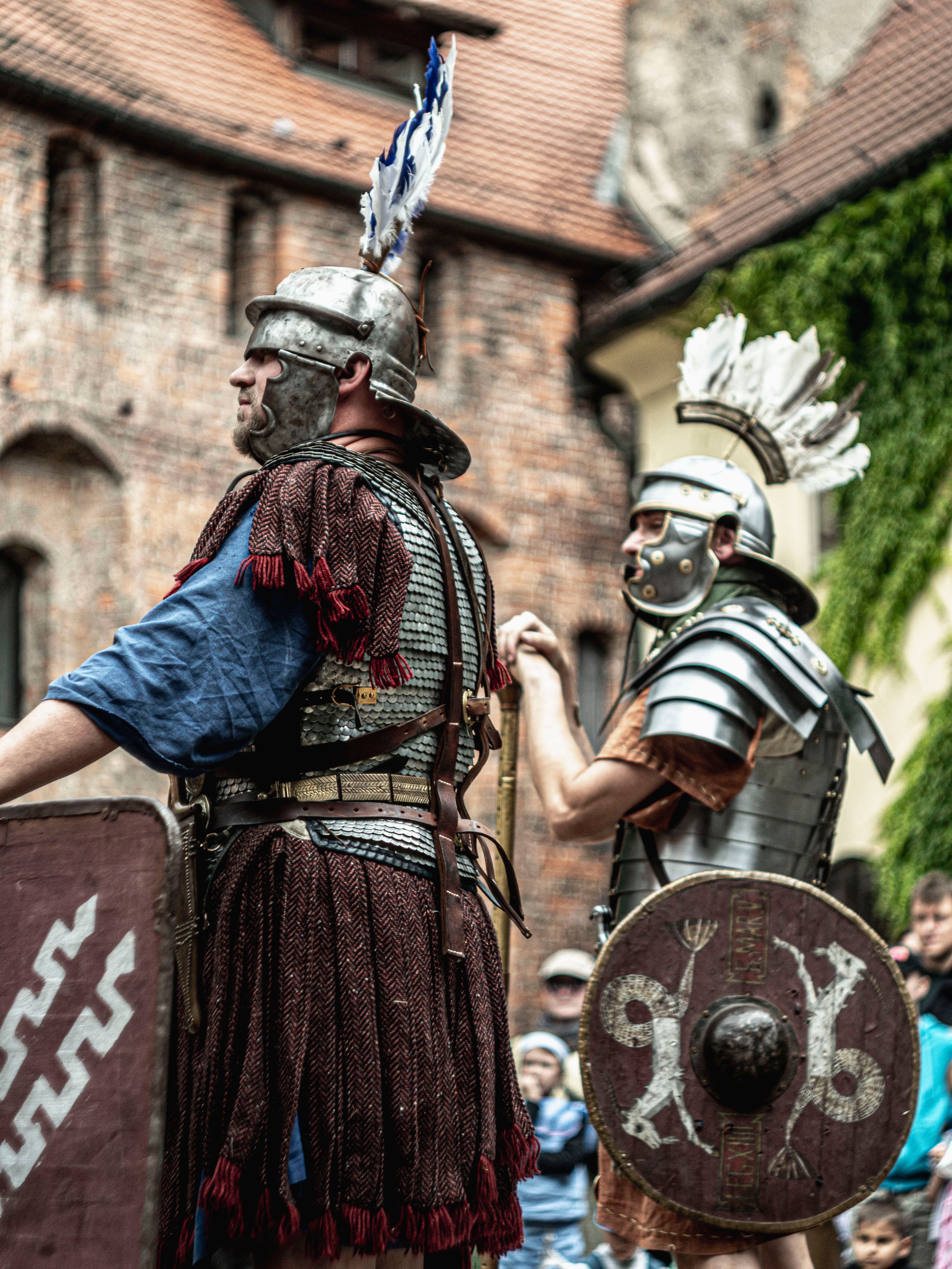 Vivid medieval reenactment featuring Roman soldiers in armor and shields outdoors.
