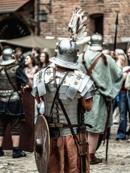 A historical reenactment scene featuring medieval knights in armor and costumes.