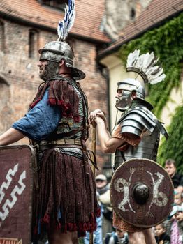 Roman soldiers in authentic armor during a historical reenactment outdoors.
