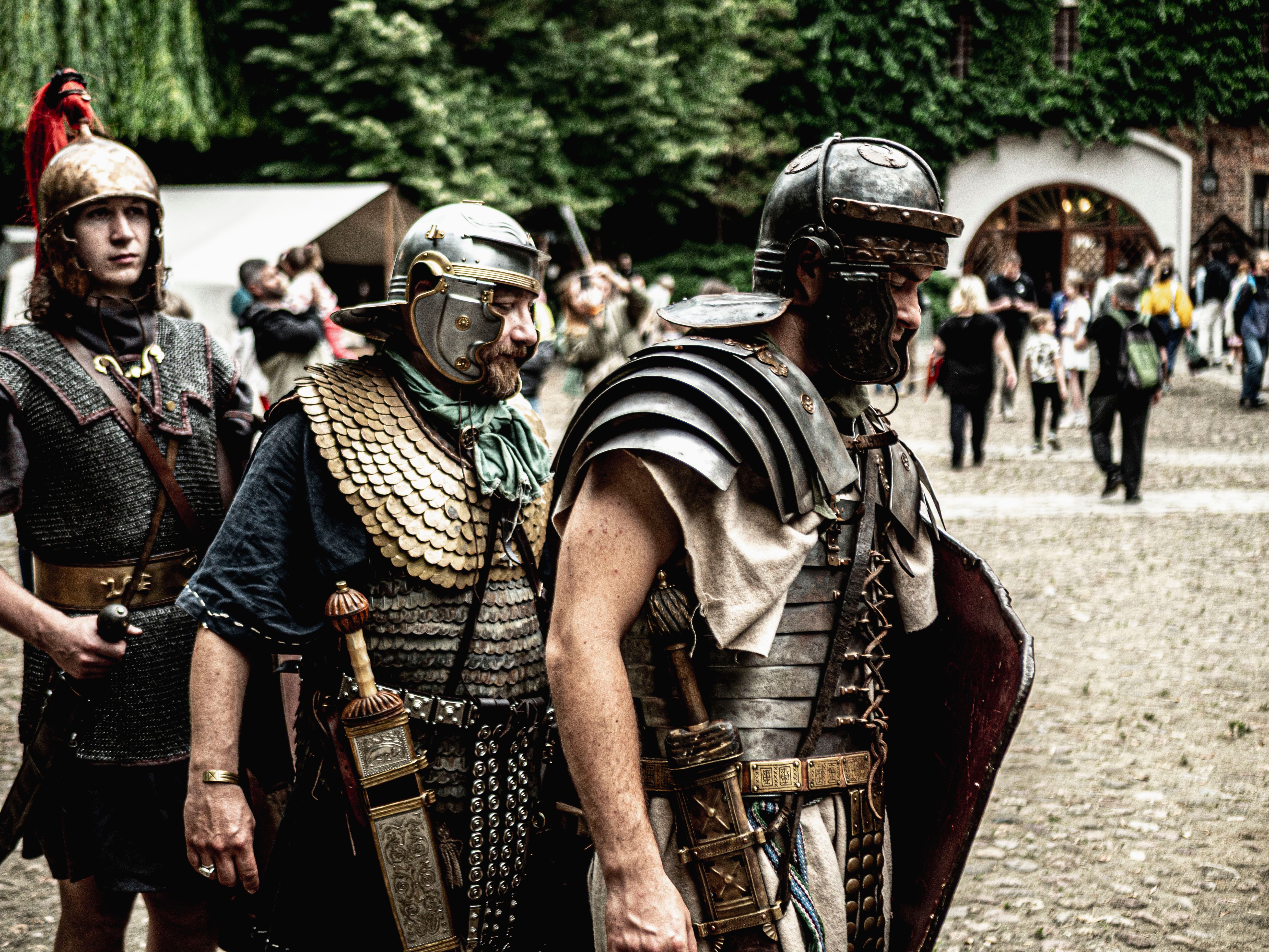 Roman soldier reenactors in historical attire at an outdoor event.
