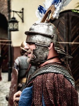 Adult male wearing medieval armor participates in a historical reenactment event.