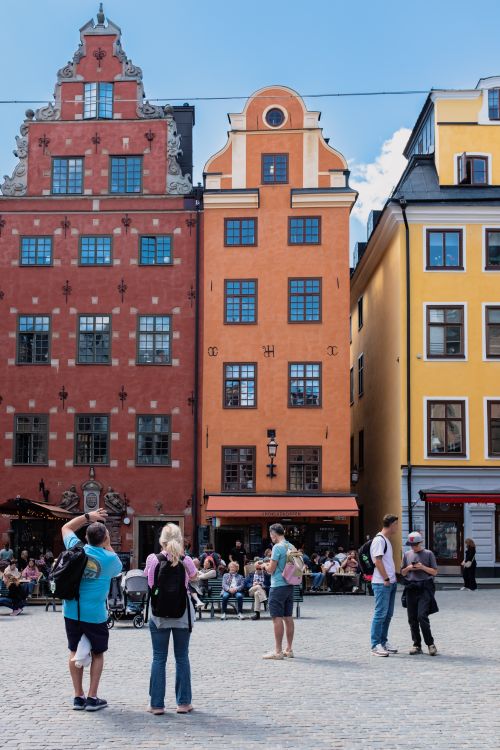 Free Lively scene in Stockholm's historic Gamla Stan with colorful buildings and crowd. Stock Photo