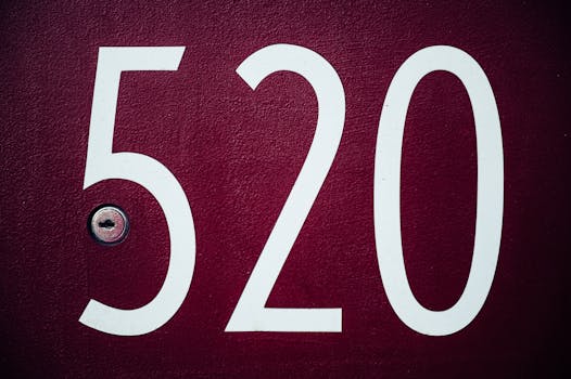 Close-up image of a red residential door with the number 520 and a keyhole.