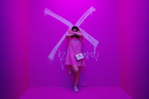 一位身穿粉色连衣裙的女子在充满活力的粉色房间里摆出涂鸦姿势