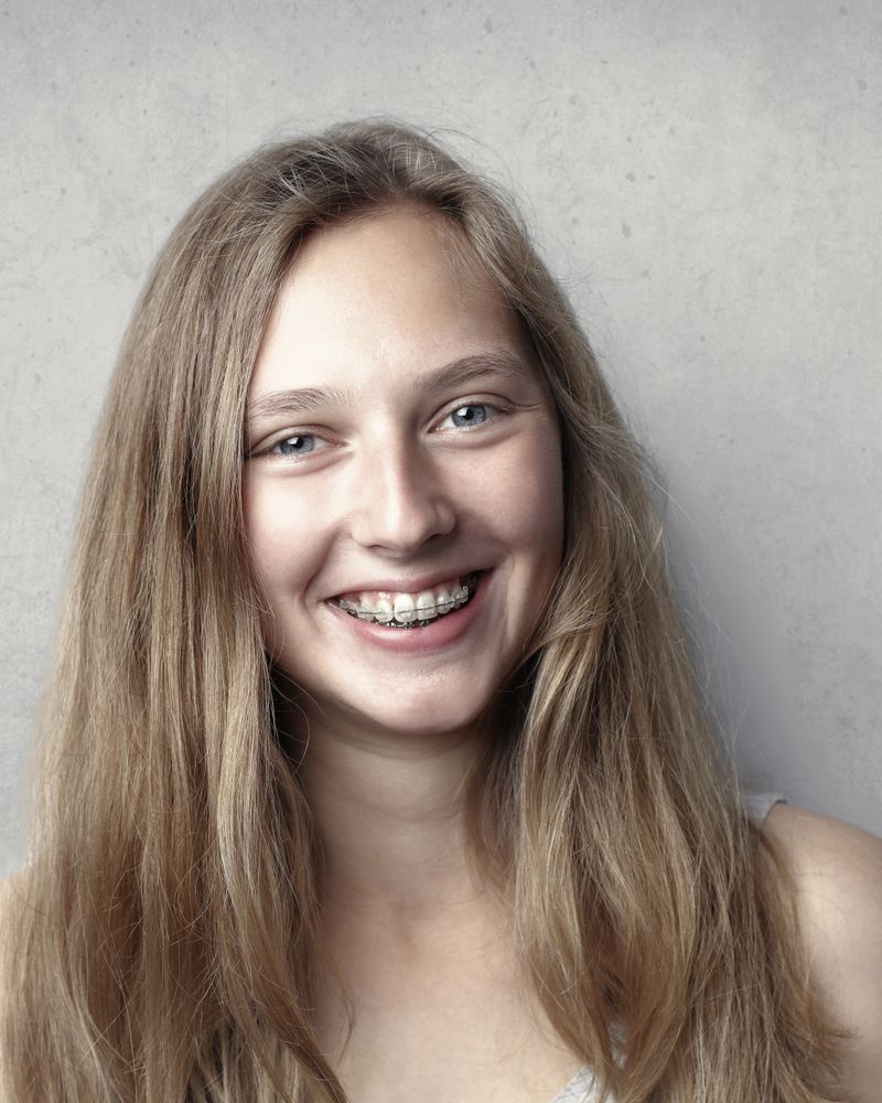 Young adult smiling with straight, even teeth