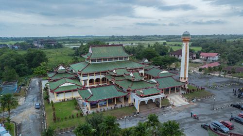 Free Aerial photo of Rantau Panjang Mosque, showcasing green roofs and Minaret amidst lush surroundings in Kelantan, Malaysia. Stock Photo