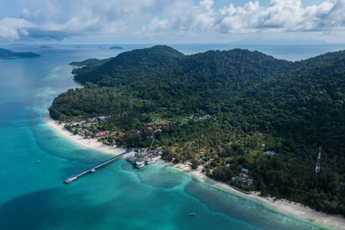 Free Stunning aerial view of a tropical island with lush greenery and turquoise waters, perfect for travel inspiration. Stock Photo