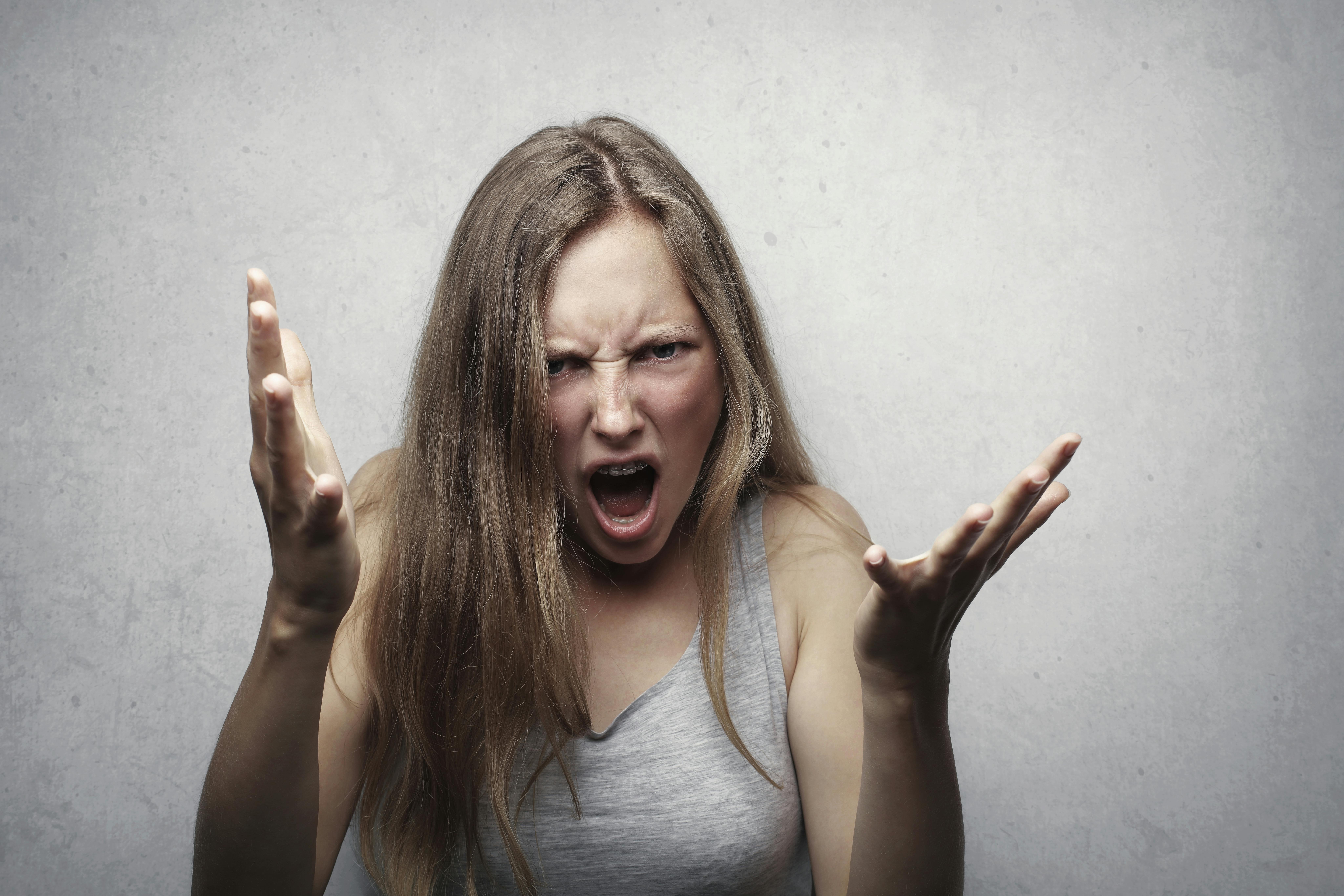 Angry woman wearing gray tank top. | Photo: Pexels