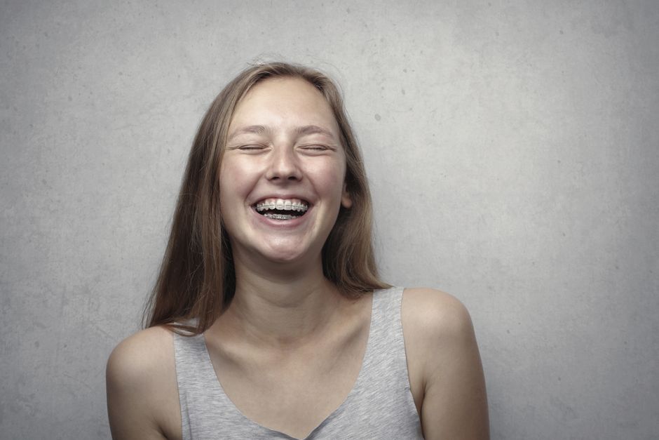 Teenager with straight white teeth smiling after orthodontic treatment Teenager with straight white teeth smiling after orthodontic treatment