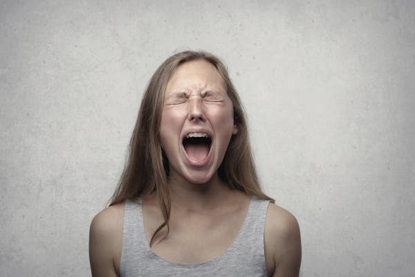Picture of woman screaming, like the frustration of a feed full of suggested posts