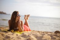 和年轻女子一起在沙滩上晒日光浴，享受无忧无虑的夏日氛围
