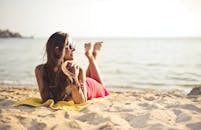 一名身穿粉色泳衣的女子正在海滩上享受阳光明媚的一天