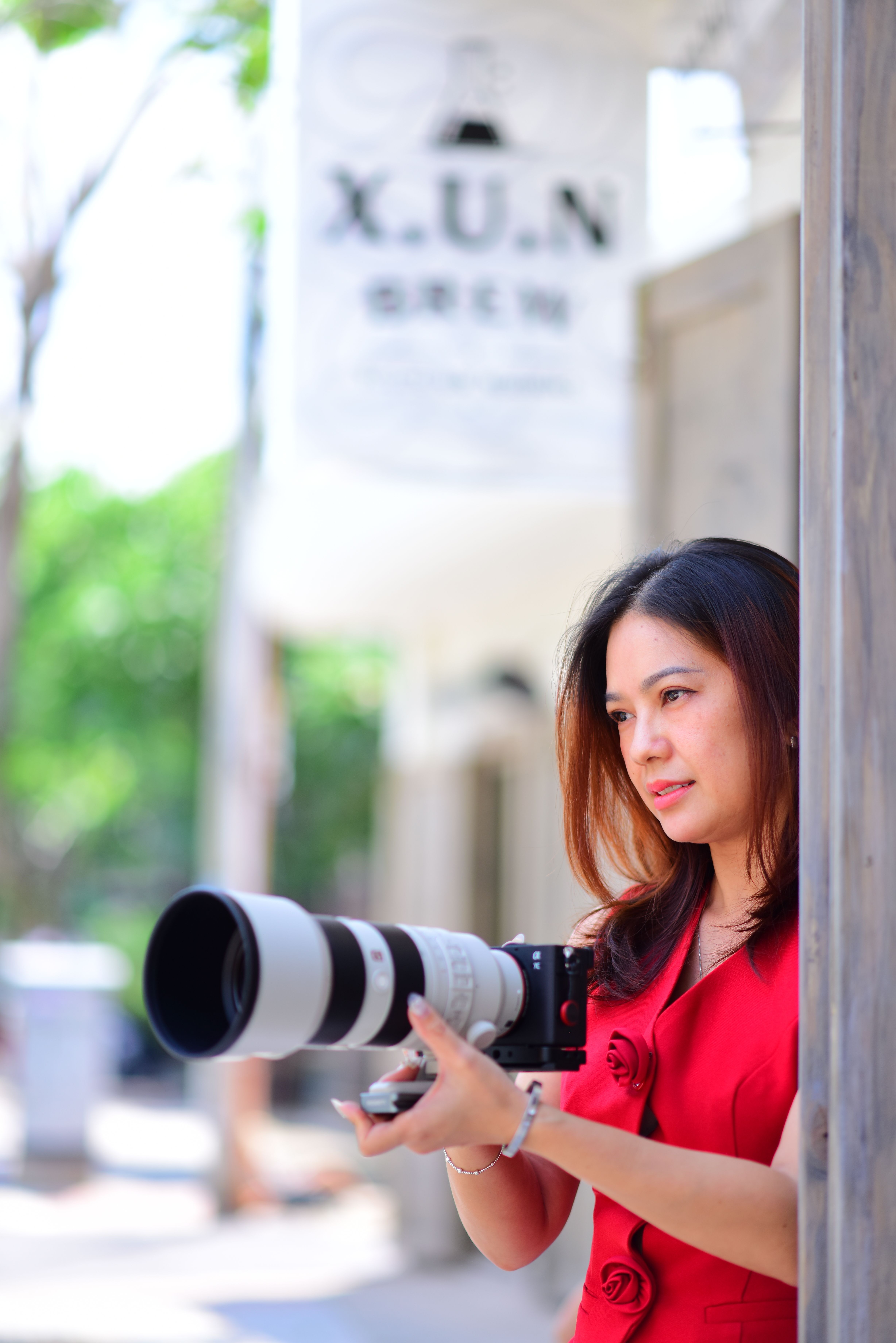 Professional female photographer with a DSLR camera in an outdoor setting.