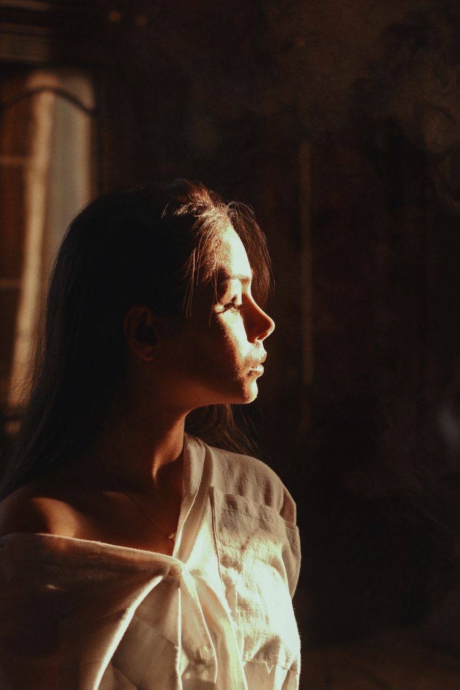 Serene woman gazing into warm light by mohadese on Pexels