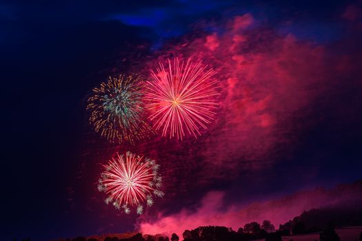 Vibrant fireworks exploding in the night sky with colorful bursts illuminating the darkness.