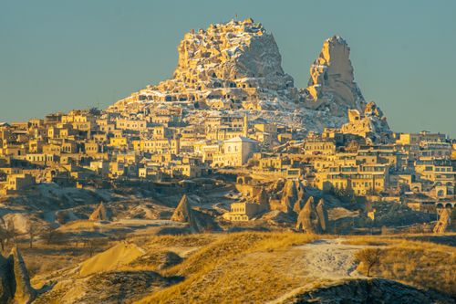 Free Stunning sunrise view of Uçhisar Castle, Göreme, Türkiye with unique rock formations. Stock Photo