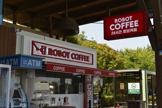 Robot Coffee shop exterior with ATM and visible signage in a lush outdoor setting.