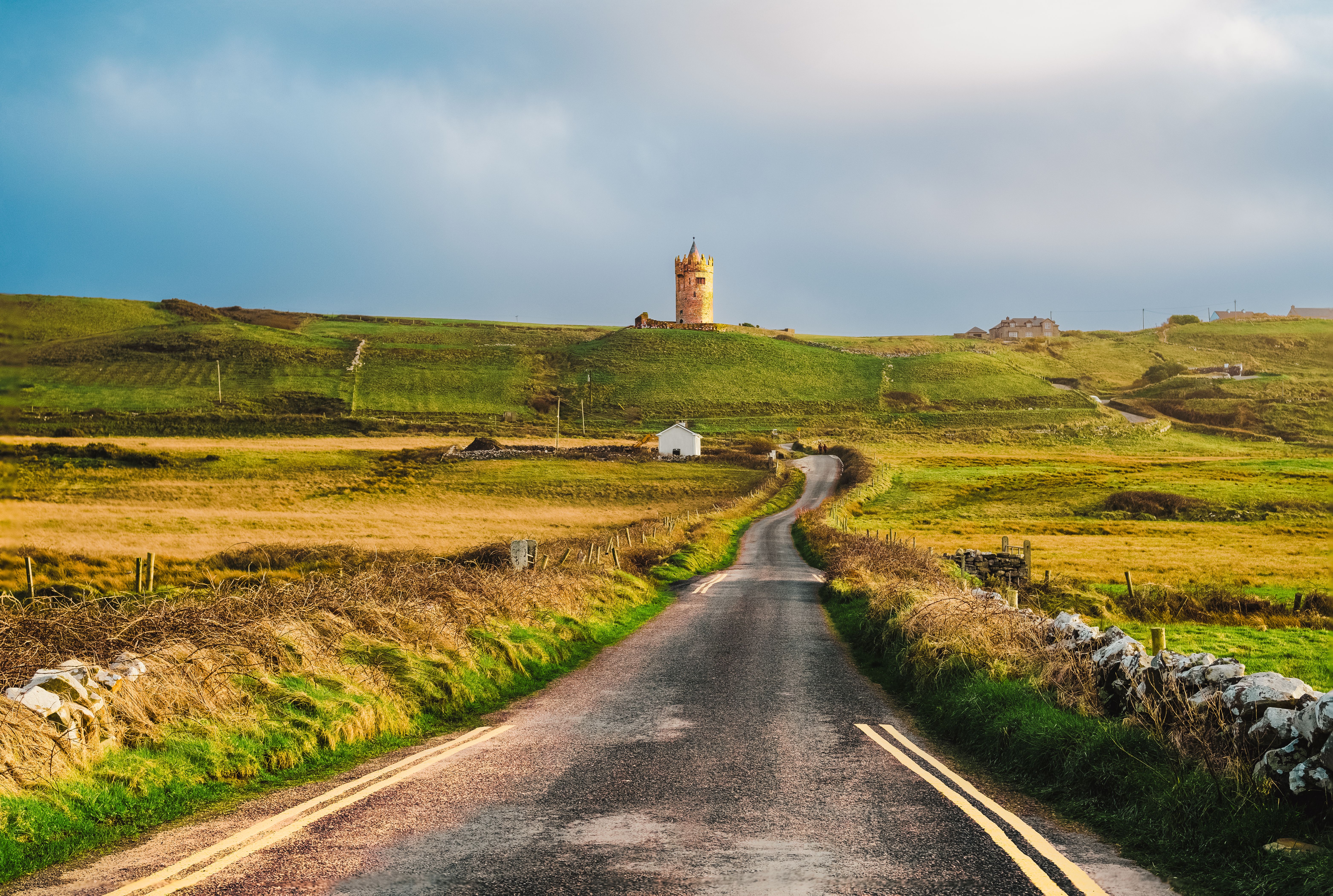 Small car navigating a narrow rural road in Ireland, ideal for exploring charming villages and scenic routes.