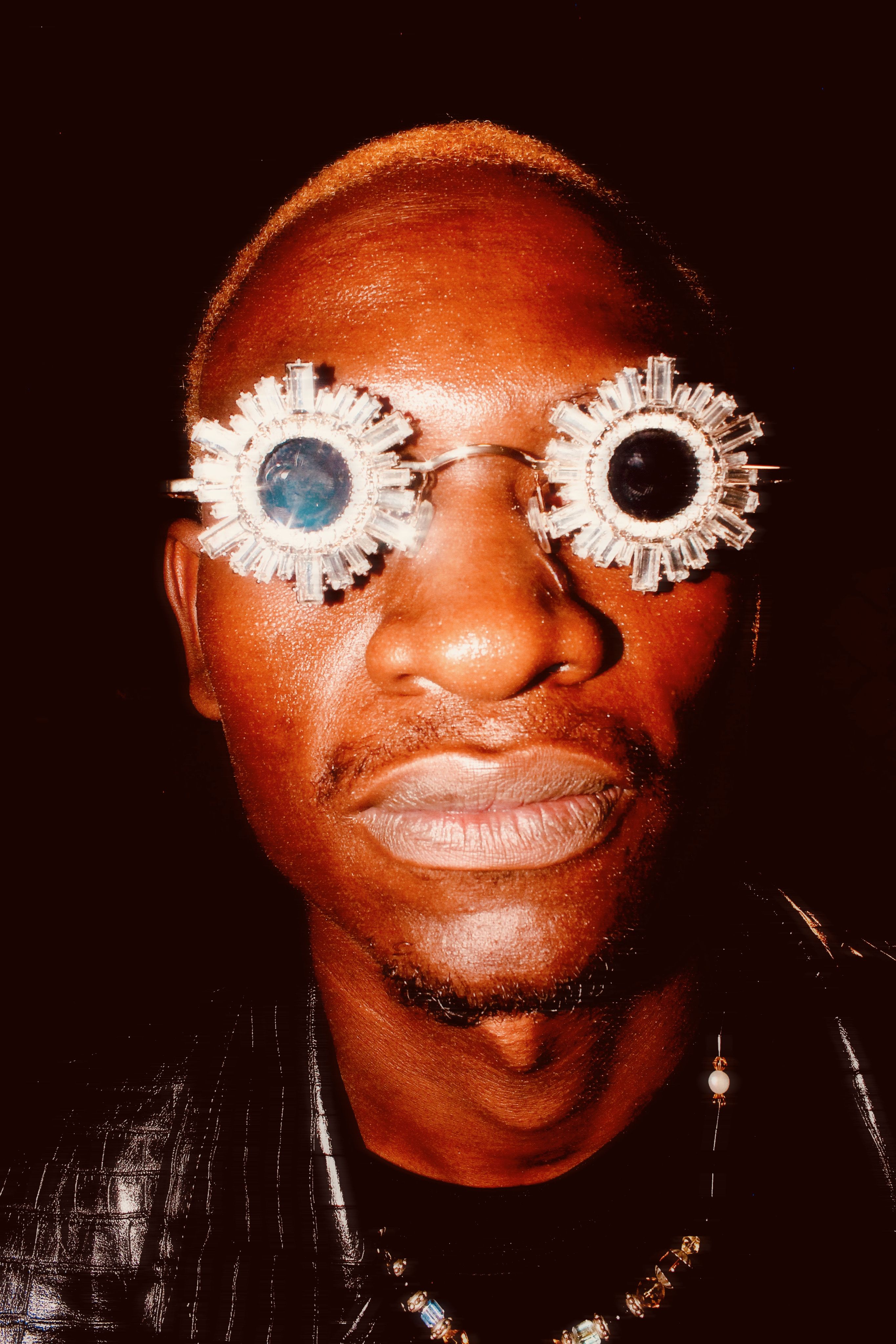 Close-up portrait of a man wearing creative, futuristic sunglasses.