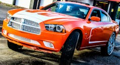 一辆闪亮的橙色老爷车停在默特尔海滩，镀铬细节尽显其风格与设计