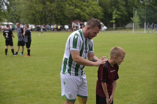 Man and child sharing a moment of camaraderie at a local soccer match in Barabás.