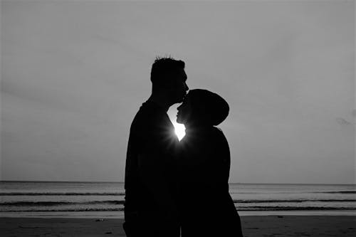 男人和女人站在海灘上的剪影