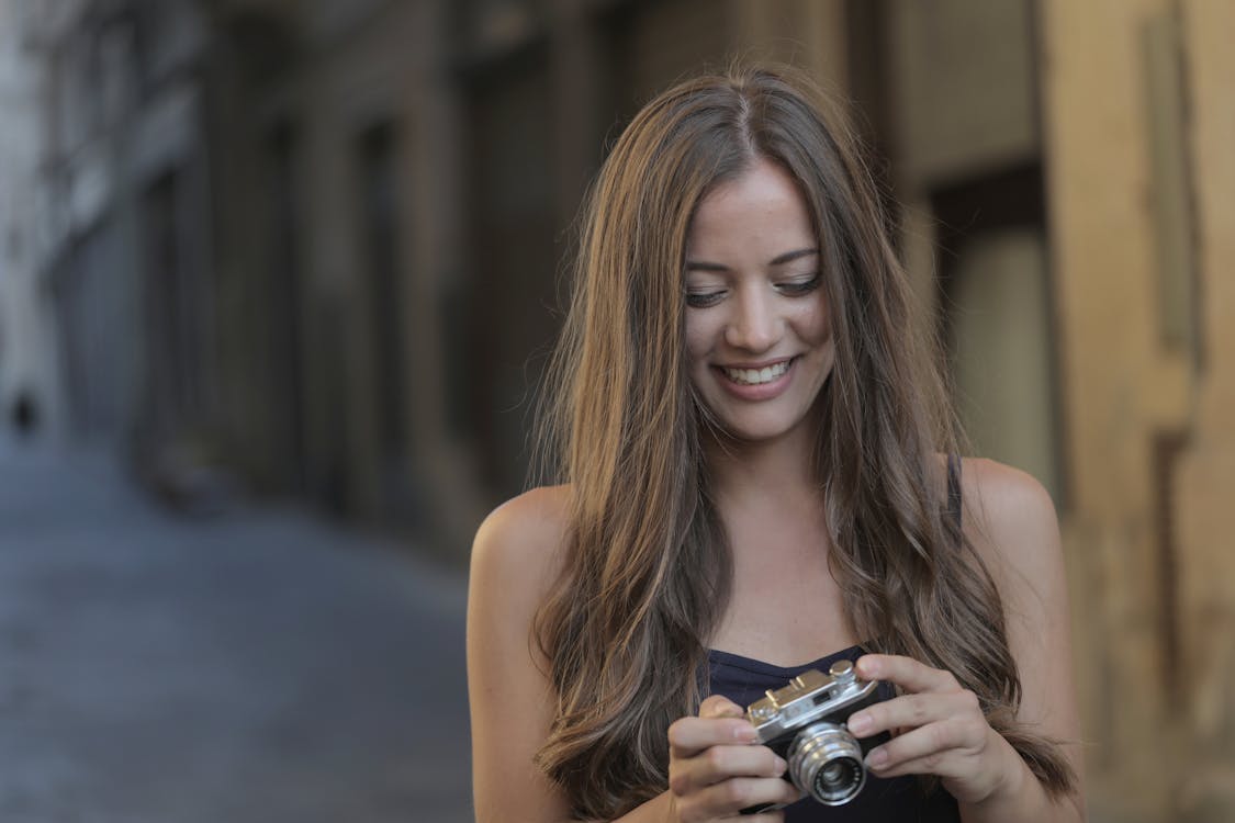 Woman in Black Tank Top Holding Silver Camera · Free Stock Photo