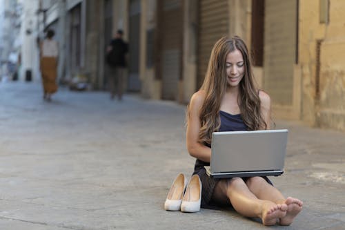 Foto Der Frau, Die Auf Boden Sitzt, Während Laptop Verwendet