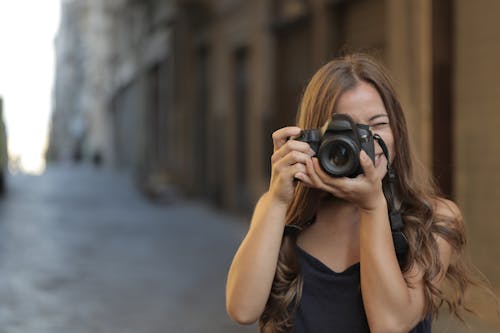 Wanita Dengan Tank Top Hitam Memegang Kamera Dslr Hitam