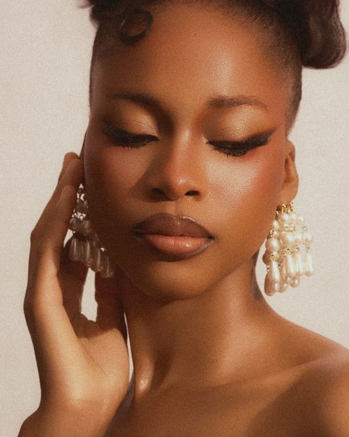 Free A close-up beauty portrait of a woman with pearl earrings and elegant makeup, emphasizing natural beauty. Stock Photo