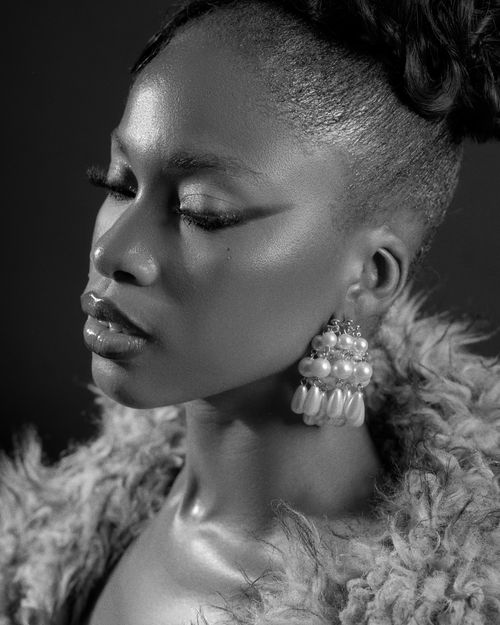 Free Elegant black and white portrait capturing the grace and style of a woman wearing pearl earrings. Stock Photo
