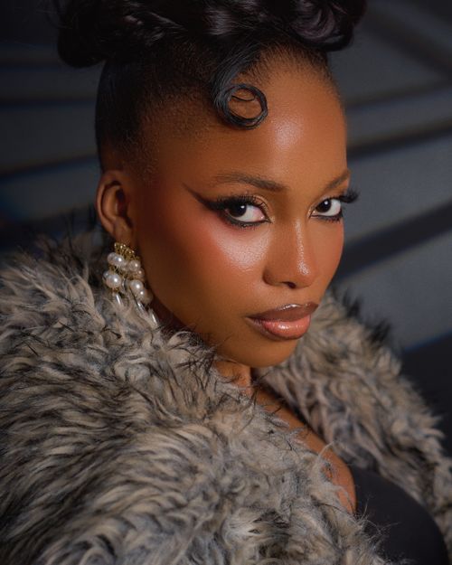 Free Captivating portrait of a Nigerian woman exuding elegance with fur attire and striking makeup. Stock Photo