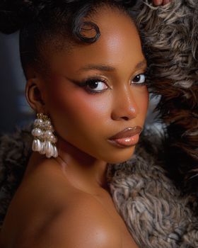 Close-up beauty portrait of a woman from Nigeria with elegant makeup and accessories.