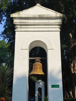 Historic bell tower in lush botanical garden setting, Jawa Barat, Indonesia.