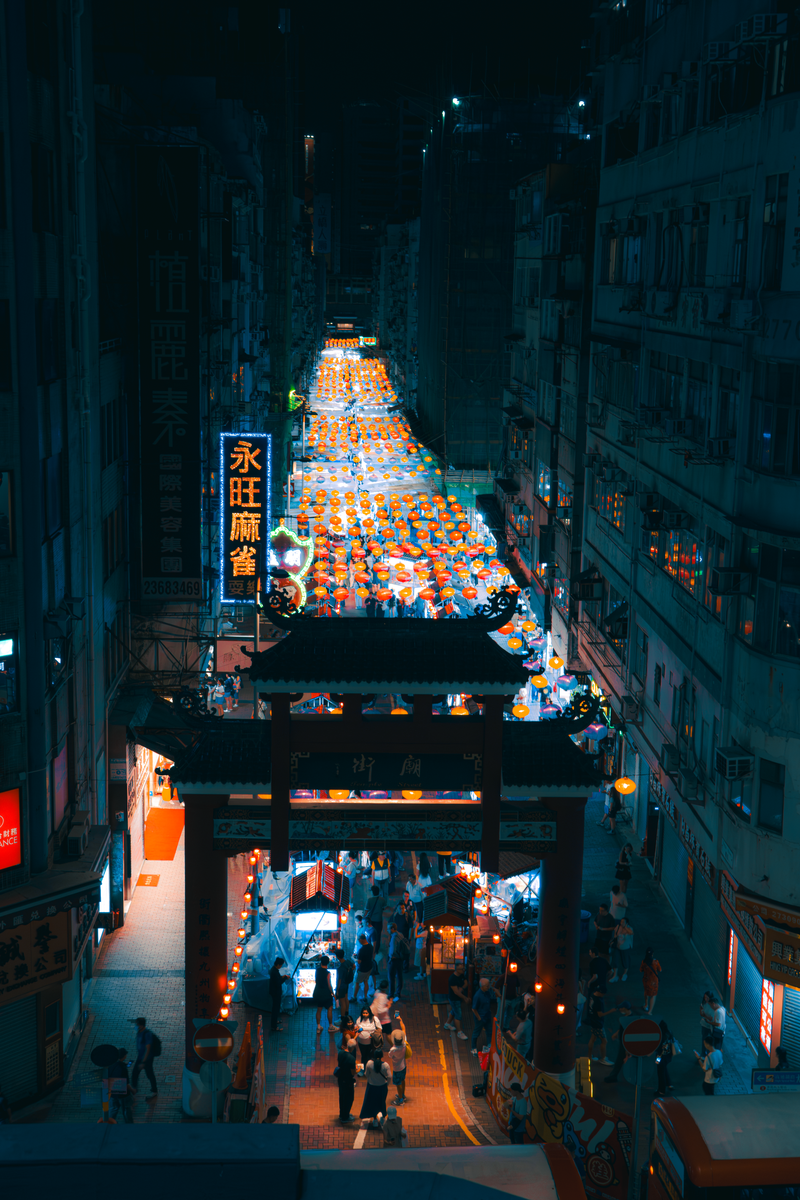 Stalls and a red archway at a Kowloon night market in Hong Kong