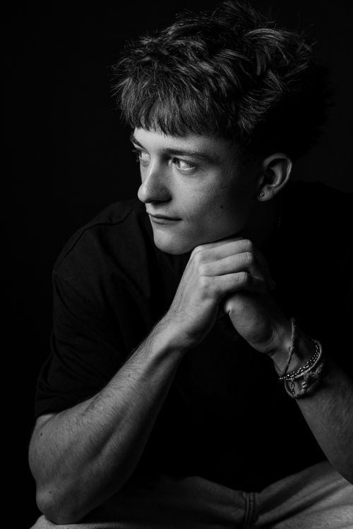 Free Striking black and white portrait of a young man looking thoughtful in a studio setting. Stock Photo