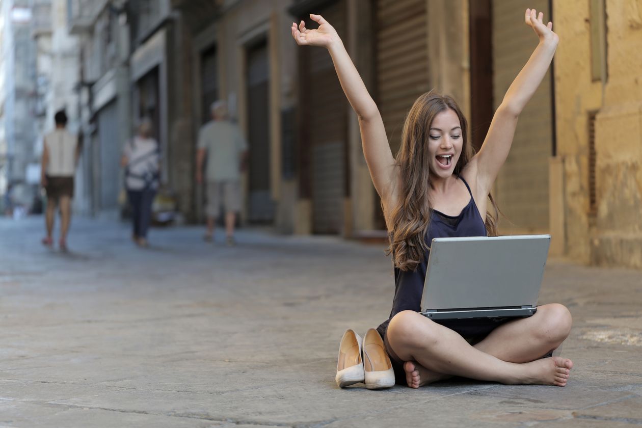 Happy new AI agency owner celebrating a first client win at her laptop