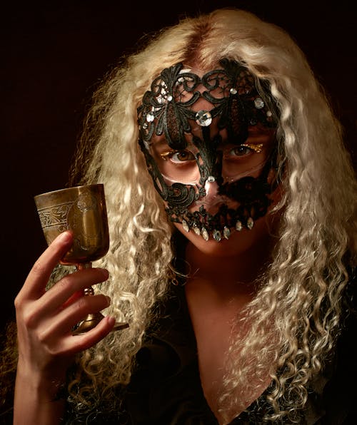 Photo of Person Wearing Masquerade Mask While Holding Goblet