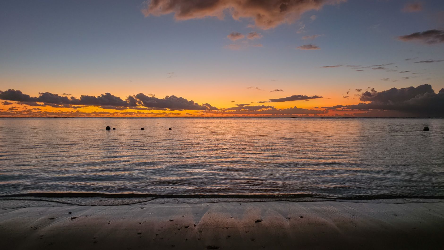 A breathtaking sunset view over the serene waters and sandy beach of Mauritius' Moka District.