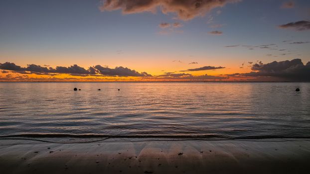 A breathtaking sunset view over the serene waters and sandy beach of Mauritius' Moka District.