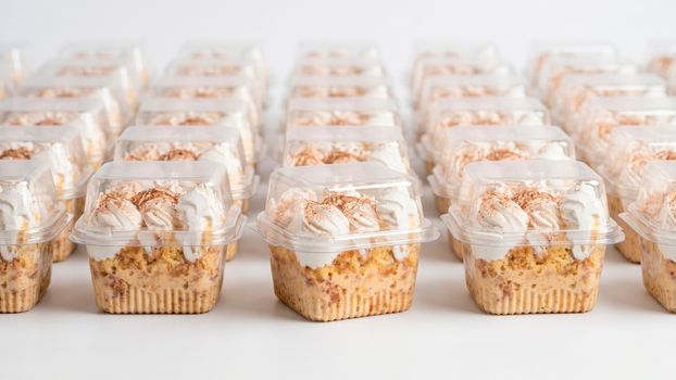 Rows of individual desserts in clear plastic containers, ready for sale or catering.