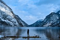冬日，一名男子静立在白雪皑皑的巴伐利亚阿尔卑斯山环抱的国王湖畔