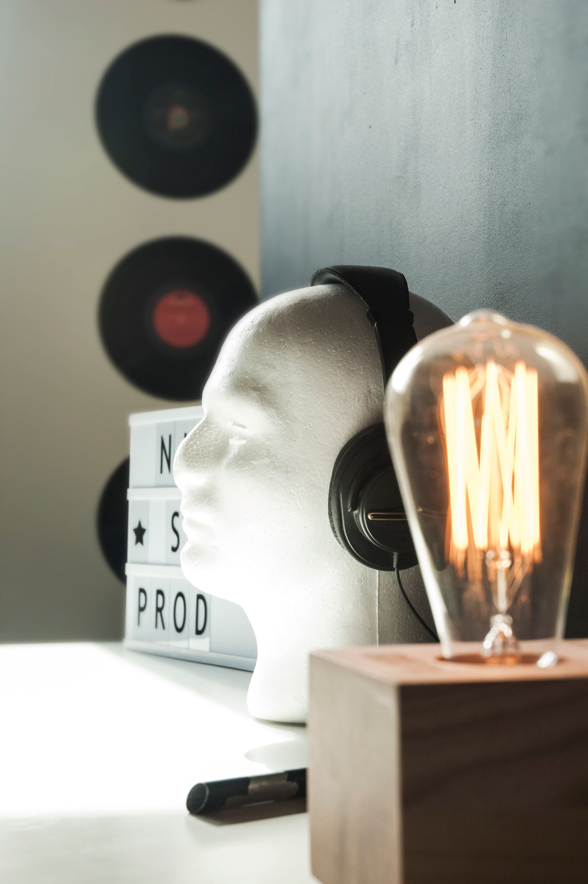 A stylish composition featuring headphones and an Edison bulb in a creative setting.