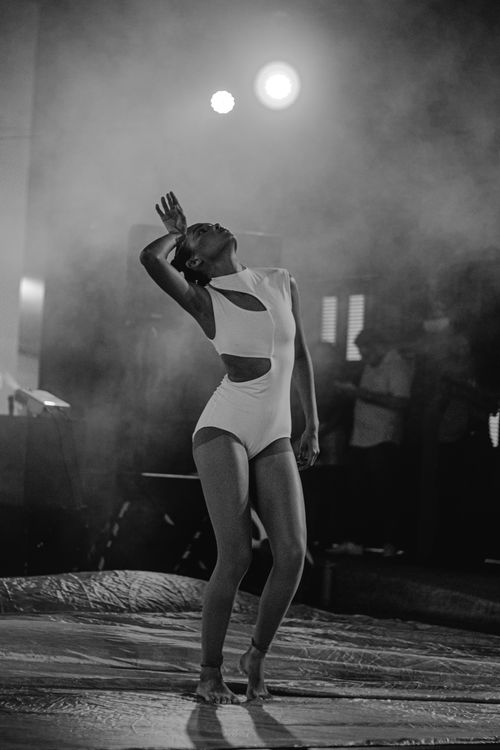 Free Black and white photo of a female dancer in a dramatic pose during a live performance. Stock Photo